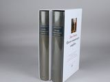 two books in a white box on a gray surface