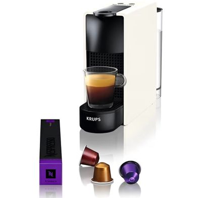 a close up of a cup of coffee next to an espresso machine