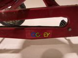 a close up of a red toy bike with a name on it