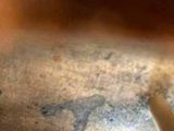 a close up of a pair of scissors on a piece of wood