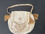an old purse with a tassel hanging from it ' s handle
