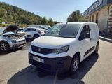 la camionnette blanche est garée devant un bâtiment dans un parking