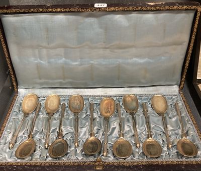 six cuillères dans un étui, posées sur une table