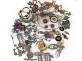 a pile of assorted jewelry on a white surface