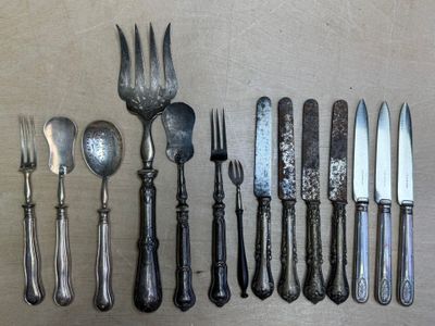 de nombreux types de couteaux et de cuillères sur la table