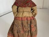 doll in a dress with a red hat and a red scarf