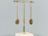 gros plan d'une paire de boucles d'oreilles sur un support
