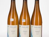 three bottles of wine sitting next to each other on a white surface