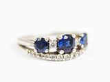a close up of a white gold ring with blue sapphires and diamonds