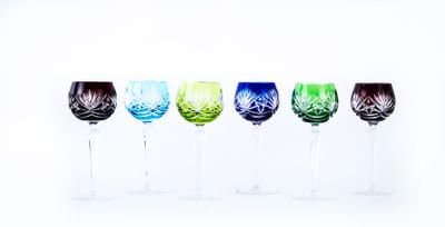 quatre verres à vin sont alignés sur une surface blanche