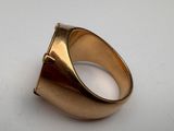 a close up of a gold ring on a white surface