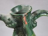 a close up of a green vase on a table