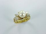 a white pearl and diamond ring on a white background