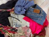 a pile of clothes that is sitting on a bed