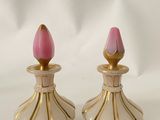une paire de bougeoirs roses et dorés sur fond blanc