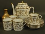 a white and gold tea set sitting on a table