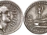 a close up of a coin with a boat on it