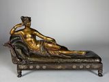 statue en bronze représentant une femme allongée sur une chaise longue