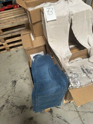 une pile de cartons et un jean par terre