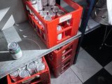 a red crate with cans and cans of soda in it