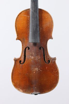 un vieux violon posé sur une surface blanche