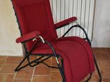 a red reclining chair in a room with a radiator