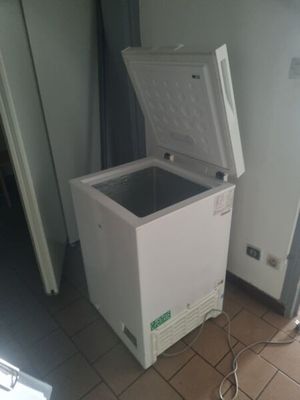 a white chest freezer sitting on a tiled floor