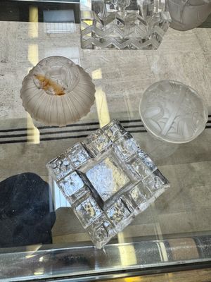 une table en verre sur laquelle sont posés quelques objets en verre