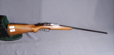 the rifle is laying on the table with a hat on top of it