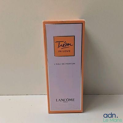an image of a bottle of perfume sitting on top of a table