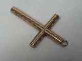 une petite croix en métal sur une surface blanche