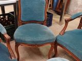 quatre chaises bleues et un tabouret dans une pièce