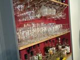 many glasses and bottles on the shelves in the kitchen