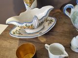 a wooden table with a teapot, saucer, and cups on it