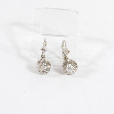 paire de boucles d'oreilles en argent ornées de cristaux transparents sur une surface transparente