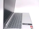 a silver laptop with a black keyboard on a white surface