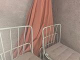 two beds in a small room with a curtain on the wall