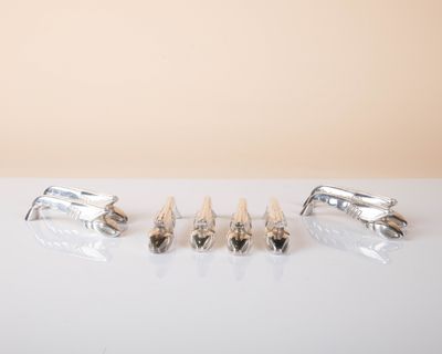 three pairs of silver cufflinks and a pair of silver cufflinks on a white surface