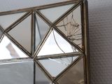 a mirror with a broken glass frame on the wall