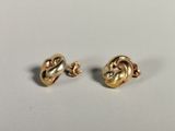 a pair of gold plated earrings on a white surface