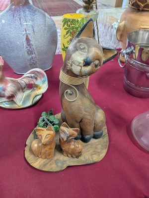 a table with a vase and a figurine of a dog on it