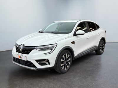 Une voiture blanche est garée dans une pièce blanche au sol noir.