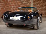 a black sports car parked in front of a brick wall