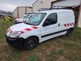 une camionnette blanche à rayures rouges garée devant un immeuble