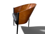 a wooden chair with a black leather seat and a shadow on the floor