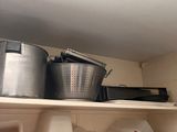 a shelf with pots and pans on top of it