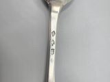 a silver spoon with a flower on it on a table