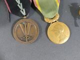 three medals are displayed on a table next to a pair of scissors