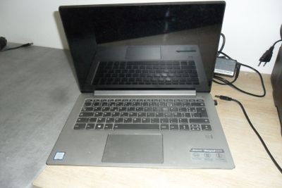 a laptop that is sitting on a table with a charger