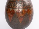 a vase that is sitting on a stand on a white surface